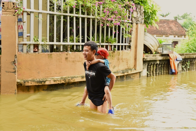 Đàm Trọng Anh cõng con đi chơi. Ảnh: Dương Đình Tường.