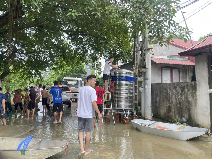 Người dân xã Nam Phương Tiến tập nập ra vào mùa lũ để tìm nguồn nước sinh hoạt. Ảnh: Minh Toàn.