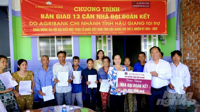 Ông Trần Quốc Diện, Phó Giám đốc Agribank Hậu Giang (thứ 2 bên phải qua) trao tượng trưng tài trợ cho hộ bà Nguyễn Thị Lâm ở ấp 6, xã Long Trị A, thị xã Long Mỹ. Ảnh: Thanh Tùng.