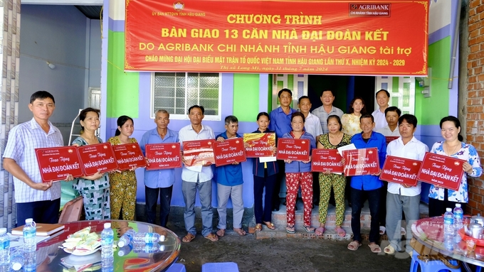 Đại diện Agribank Hậu Giang và chính quyền địa phương trao tượng trưng cho 13 hộ dân nhận được hỗ trợ xây dựng nhà đại đoàn kết. Ảnh: Thanh Tùng.