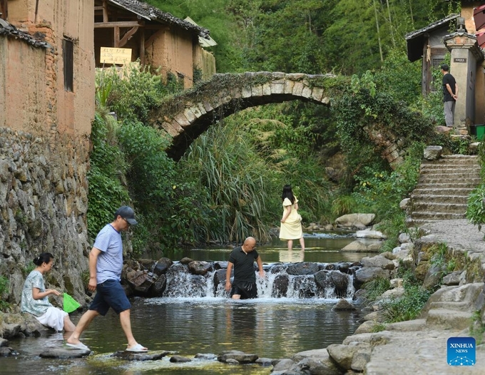 Tourists visit Songzhuang Village in Songyang County, east China's Zhejiang Province, July 17, 2024. Nestled in the mountains, Songzhuang Village of Songyang County boasts a history of over 600 years and preserves many traditional residences. In recent years, local government has renovated old houses and ancient paths and introduced new business forms to attract young talents to start their businesses there. Photo: Xinhua