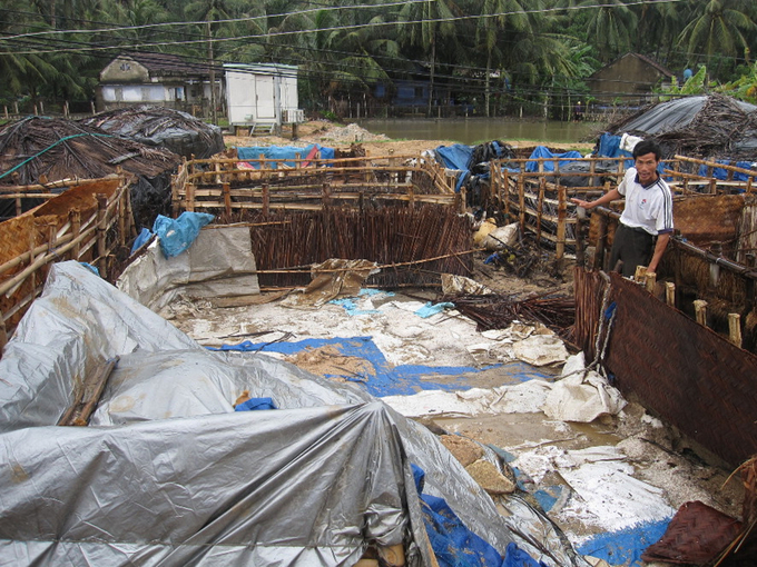 Anh Lê Văn Duyệt bên đống muối bị tan chảy do mưa lũ (ảnh chụp năm 2010). Ảnh: Võ Thanh Kỳ.