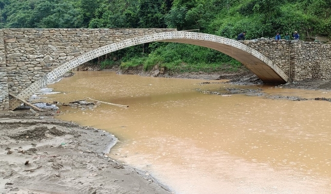 Khơi thông dòng chảy, khẩn trương xây dựng cầu qua suối để đảm bảo cho người dân đi lại an toàn. Ảnh: Thanh Tiến.