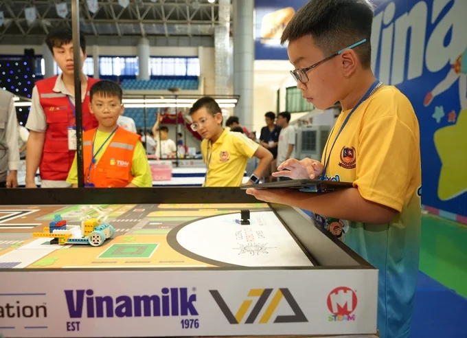 Contestants focus on finding solutions for robots to tackle the challenges in the competition tasks. Photo: Vi Nam.