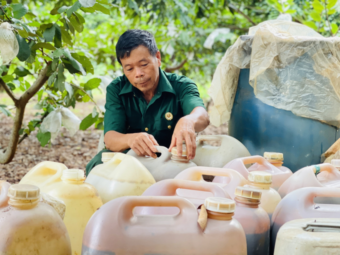 Dang Thanh Van next to his cans of self-made fish protein to fertilize the garden. Photo: Dang Lam.