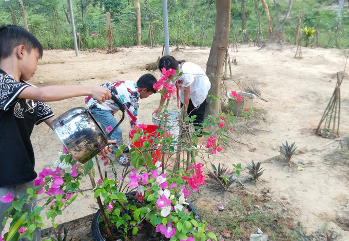 Học sinh bản Đoòng chăm sóc vườn hoa trồng ở lớp học như nuôi ước mơ được đi học cao hơn. Ảnh: T. Đức.