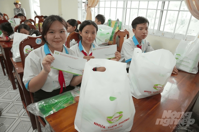 Chương trình 'Cầu nối yêu thương' tặng 20 suất quà em học sinh hiếu học vượt khó (mỗi suất trị giá 700 ngàn đồng) tại xã An Lợi. Ảnh: Trọng Linh.