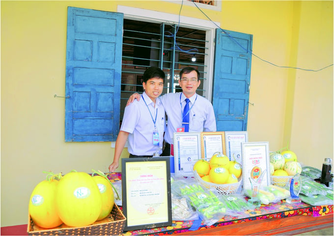 Pham Van Tan, Director of Agricultural Cooperative 2 Nhon Tho (right), and a young agricultural extension officer, presenting the cooperative’s OCOP products. Photo: V.D.T.