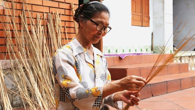 Mrs. Bui Thi Man (Yen Duc commune, Dong Trieu town) is choosing straws with beautiful colors and standard toughness to braid brooms. Photo: Thanh Phuong.