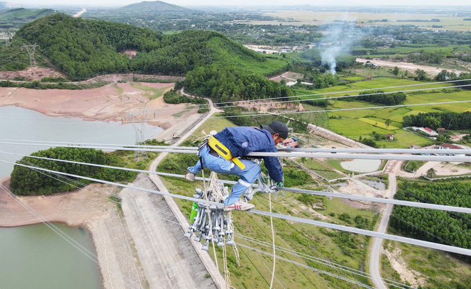 Công nhân vắt vẻo thi công đường dây ở độ cao hàng chục mét.