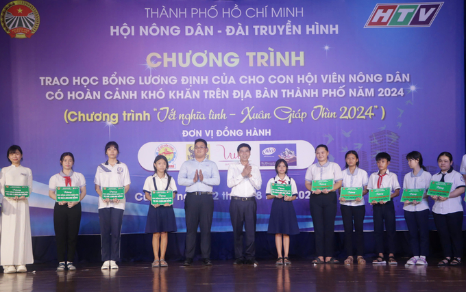 Ông Lê Minh Dũng, Chủ tịch Hội Nông dân TP.HCM (đứng giữa - áo trắng) và đại diện Công ty liên doanh Bio-Pharmachemie trao tặng các suất học bổng cho con em hội viên nông dân. Ảnh: Ng.N.