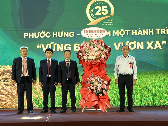 Ông Nguyễn Thanh Truyền, Giám đốc Sở NN-PTNT Long An (bìa phải) tặng hoa chúc mừng Ban lãnh đạo Phân bón Phước Hưng. Ảnh: Đức Trung.