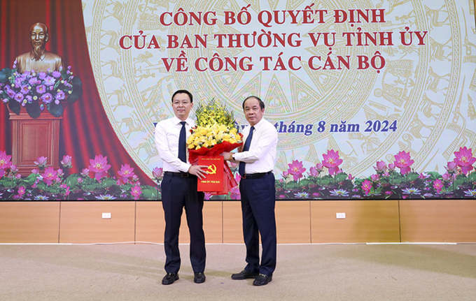 Phó Bí thư thường trực Tỉnh ủy Yên Bái trao quyết định và tặng hoa ông An Hoàng Linh - tân Chánh Văn phòng Tỉnh ủy Yên Bái. Ảnh: Thanh Tiến.