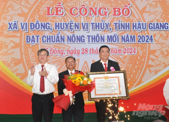 Phó Chủ tịch Thường trực UBND tỉnh Hậu Giang Trương Cảnh Tuyên, trao quyết định của UBND tỉnh công nhận xã Vị Đông đạt chuẩn nông thôn mới cho đại diện chính quyền xã. Ảnh: Trung Chánh.