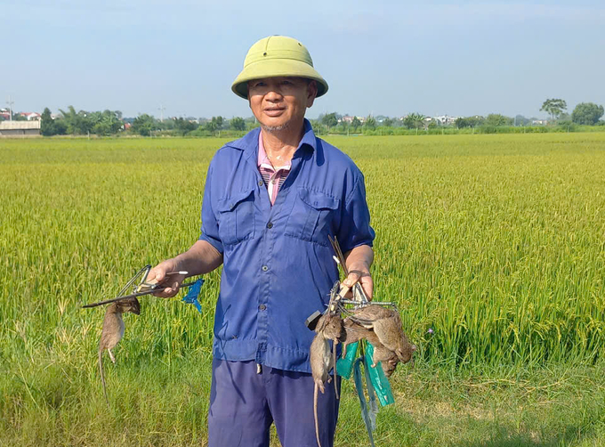 Ông Tạ Văn Song,xã Đông Lỗ và thành quả thu được sau một đêm đặt bẫy bán nguyệt trên đồng ruộng. Ảnh: Trần My.