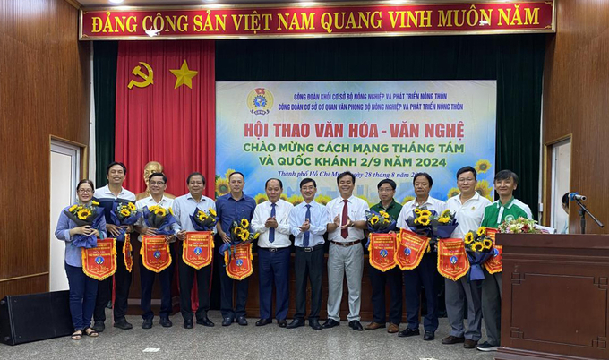 Ông Nguyễn Duy Vũ và ông Lê Viết Bình trao hoa và cờ lưu niệm cho các đơn vị tham gia hội thao văn hóa văn nghệ.