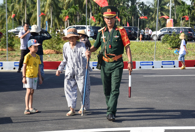 Vui mừng vì có tuyến đường kết nối đường ven biển trên địa bàn thị xã Hoài Nhơn, cụ bà bất chấp tuổi già chống gậy đi dự lễ khánh thành. Ảnh: V.Đ.T.