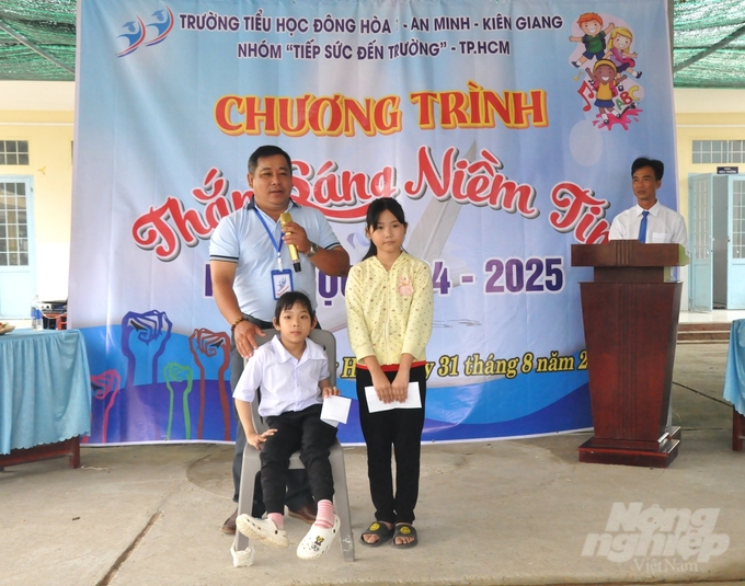 Hai em học sinh Trường Tiểu học Đông Hòa 1 có hoàn cảnh đặc biệt khó khăn được hỗ trợ bằng tiền để đóng học phí, mua bảo hiểm và dụng cụ học tập. Ảnh: Trung Chánh.