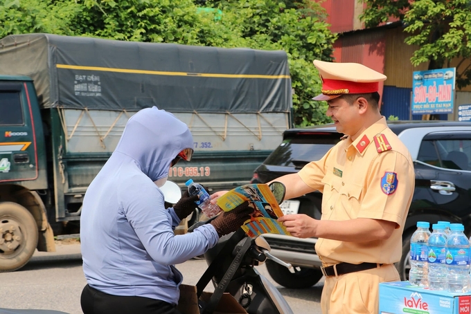 Lực lượng Cảnh sát giao thông Thái Nguyên cấp phát tờ rơi tuyên truyền về an toàn giao thông và nước lọc miễn phí cho người dân trên đường về quê nghỉ lễ. Ảnh: Công an tỉnh Thái Nguyên.