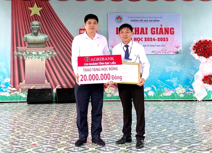 Dương Quốc Sử, Giám đốc Agribank chi nhánh tỉnh Bạc Liêu (bên trái) gửi tặng học bổng cho Trường Tiểu học Kim Đồng, huyện Đông Hải. Ảnh: Minh Khương.