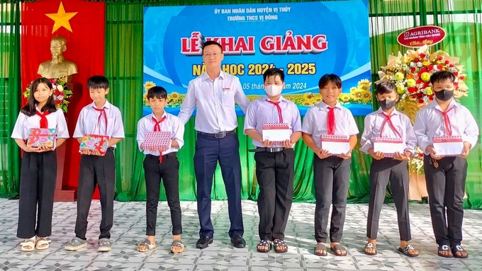 Đại diện Agribank Hậu Giang trao tặng học bổng và tập vở cho học sinh Trường THCS Vị Đông. Ảnh: Thanh Tùng.