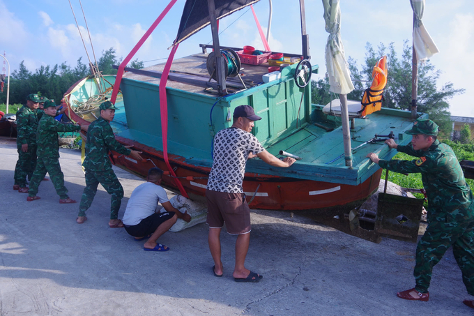 Lực lượng bộ đội biên phòng hỗ trợ ngư dân chằng chống tàu, thuyền. Ảnh: CTV.