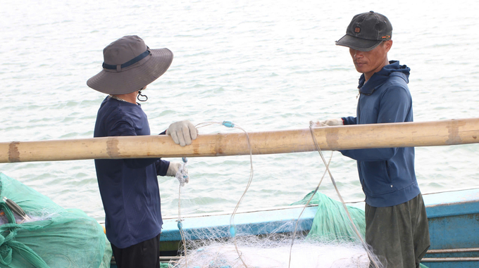 Sau khi neo đậu an toàn, ngư dân gấp rút thu lưới trước khi cơn bão đổ bộ. Ảnh: Thanh Phương.