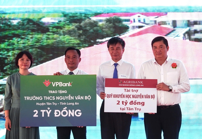 Ông Huỳnh Minh Tuấn, Giám đốc Agribank chi nhánh Đông Long An (bên phải) trao tặng 2 tỷ đồng đóng góp cho Quỹ khuyến học Nguyễn Văn Bộ. Ảnh: Minh Khương.