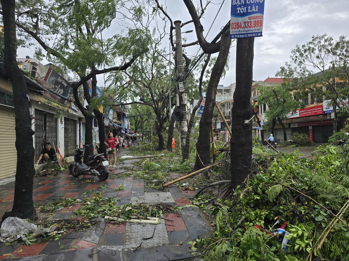 Hàng loạt hàng quán đóng cửa, gần như không có quán ăn sáng nào hoạt động, người dân đổ ra đường dọn dẹp cây cối gãy đổ chắn đường và lối đi. Ảnh: Đinh Mười.