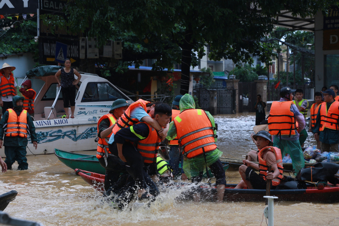 Lực lượng chức năng đang chạy đua để đưa người dân ra khỏi vùng bị ngập lụt. Ảnh: Hồng Nhân.