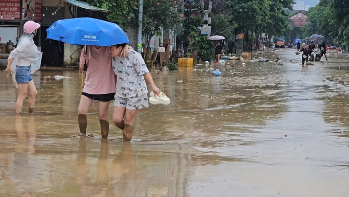 Người dân Lào Cai lội bùn đi trong phố. Ảnh: H.Đ.