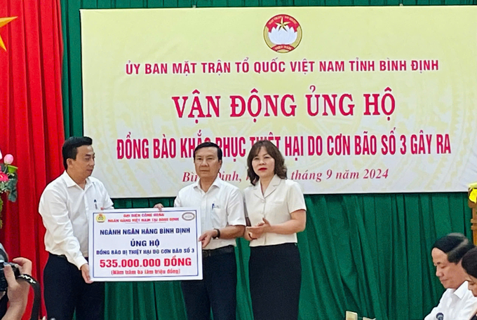 Đại diện Công đoàn ngành Ngân hàng Việt Nam tại Bình Định trao bảng tượng trưng ủng hộ 535 triệu đồng. Ảnh: V.Đ.T.