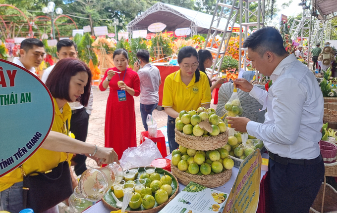 Các du khách, đại biểu thưởng thức chanh Hoàng kim VN77 tại hội chợ huyện Tân Phước. Ảnh: Quang Yên.