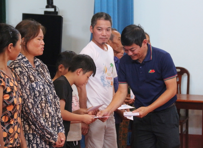 Ông Trần Văn Cao, Phó Tổng Biên tập Báo Nông nghiệp Việt Nam trao phần quà cho 1 cháu nhỏ xã Úc Kỳ. Ảnh: Phạm Hiếu.