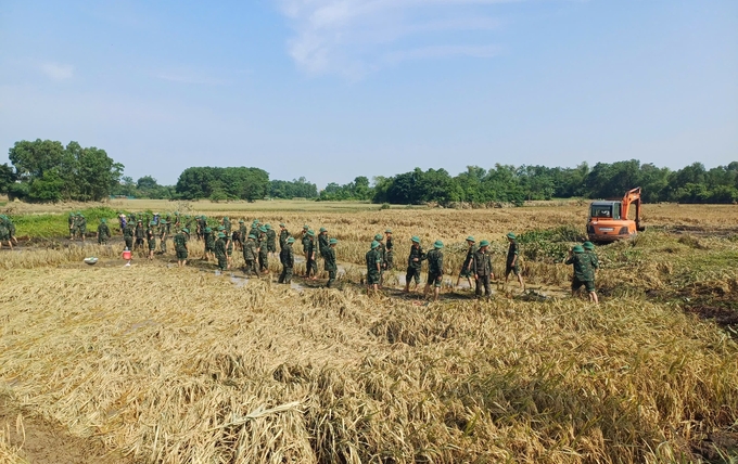 Các chiến sỹ không quản mưa nắng, thắt chặt tình quân dân khi đồng hành cùng nhân dân khắc phục hậu quả mưa bão. Ảnh: Quang Linh.