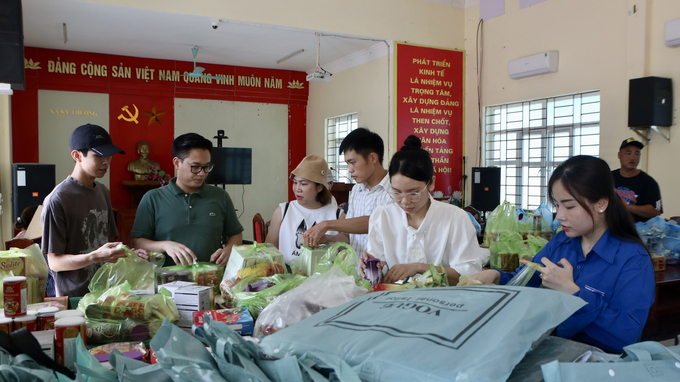 Các thành viên trong đoàn thiện nguyện chia đồ thành từng túi nhỏ để trao đến những hộ dân. Ảnh: Thanh Phương.