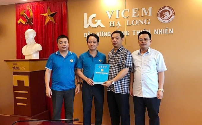 Ông Đỗ Văn Quảng, Phó Chủ tịch Công đoàn Xây dựng Việt Nam (thứ 2 từ trái qua) trao hỗ trợ tại Công ty Cổ phần Xi măng Vicem Hạ Long.