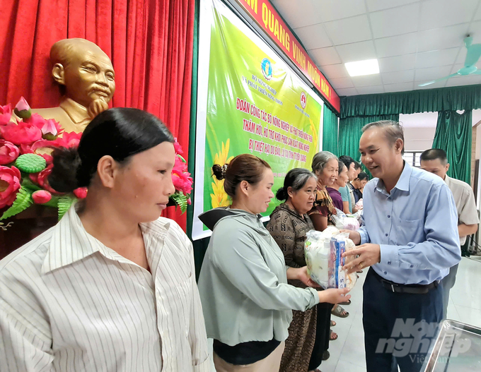 Thứ trưởng Phùng Đức Tiến tặng quà cho những hộ gia đình tại xã Tân Long bị thiệt hại do bão lũ gây ra. Ảnh: Đào Thanh.