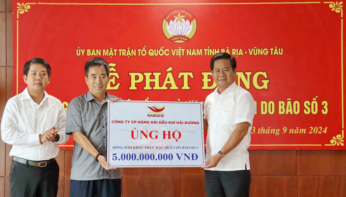 Ông Bùi Chí Thành, Chủ tịch Ủy ban Mặt trận Tổ quốc Việt Nam tỉnh (bìa phải), nhận bảng tượng trưng số tiền ủng hộ từ doanh nghiệp.