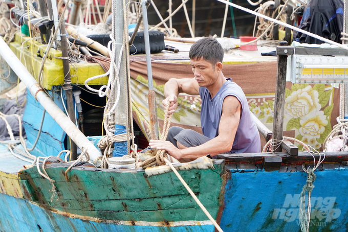 Người dân kiểm tra lại dây neo đậu tàu thuyền trước khi lên bờ.