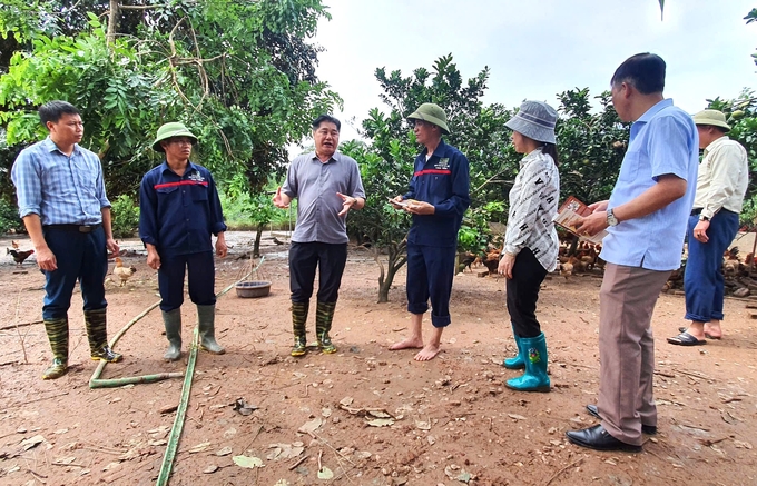 Ông Lê Quốc Thanh, Giám đốc Trung tâm Khuyến nông Quốc gia (thứ 3 từ trái qua) chia sẻ về công tác xử lý môi trường, chăm sóc, nâng cao sức khỏe, bổ sung dinh dưỡng cho đàn gia cầm cho người dân sau mưa lũ. Ảnh: Phạm Hiếu.