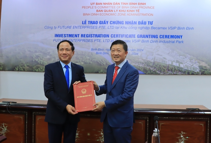 Chairman of the Binh Dinh Provincial People\'s Committee, Pham Anh Tuan (far left), presents the investment registration certificate for the cold-dried instant coffee production plant project to Mr. Tang Wang Cheow, Chairman of Food Empire Holdings Group. Photo: V.D.T.