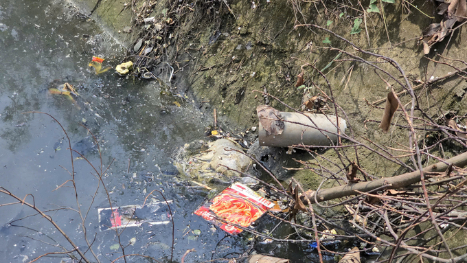 Wastewater and garbage surround irrigation canals. Photo: Dinh Muoi.