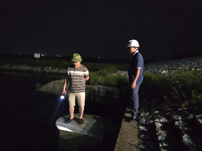 Do Van Trai, Chairman of Da Do Exploiting Irrigation One Member Company Limited, uses a light to check the drainage in Kien Quoc commune, Kien Thuy district. Photo: Dinh Muoi.