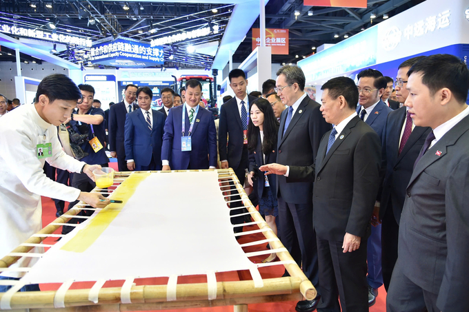 Leaders of Vietnam and China observe an artisan demonstrating the hand-dyeing silk process. Photo: ITPC.