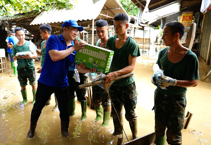 Vinamilk đem sữa, nước uống đến tận tay người dân và lực lượng đang làm nhiệm vụ khắc phục hậu quả bão lũ. Ảnh: Tịnh Không.