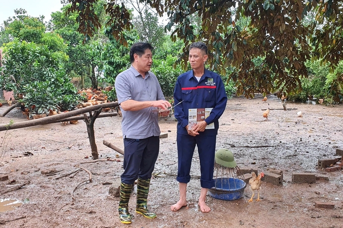 Ông Lê Quốc Thanh (trái), Giám đốc Trung tâm Khuyến nông Quốc gia hướng dẫn người dân Thái Nguyên xử lý môi trường sau mưa lũ. Ảnh: Phạm Hiếu.