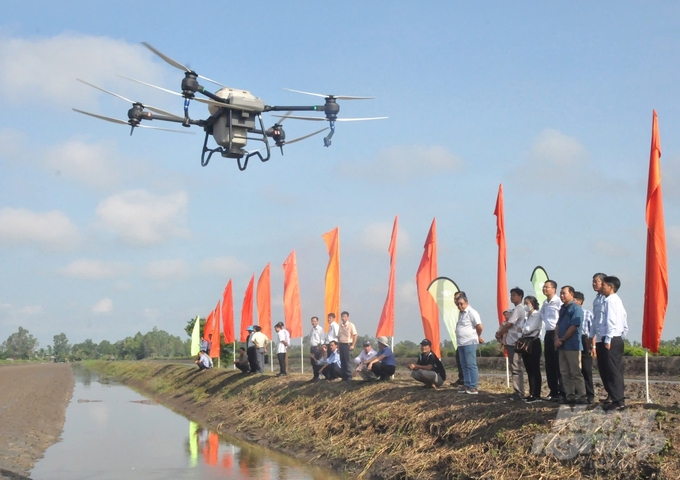 Trình diễn thực hành ứng dụng công nghệ tiên tiến trong sản xuất lúa bằng drone, giảm lượng giống gieo sạ và giảm chi phí công lao động trên cánh đồng thí điểm 'Lúa hữu cơ - Tôm sinh thái'. Ảnh: Trung Chánh.