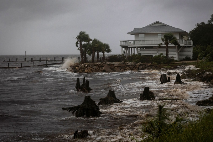 Sóng biển đổ vào bờ kè nhà tại Eastpoint, Florida. Ảnh: Reuters.