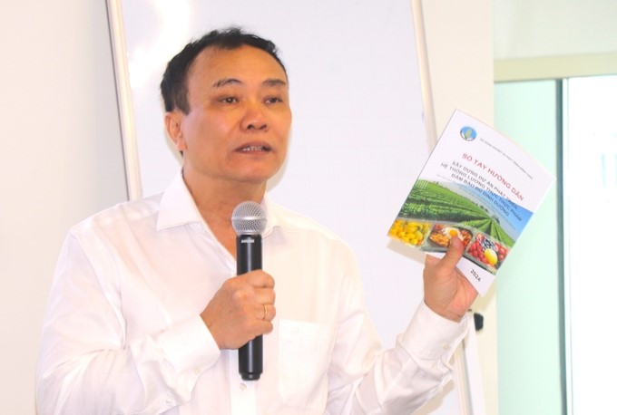 Mr. Le Duc Thinh, Director of the Department of Cooperatives and Rural Development, introduced the Handbook for Buiding the Project on Developing Food Systems Ensuring Adequate Nutrition. Photo: Kim Anh.